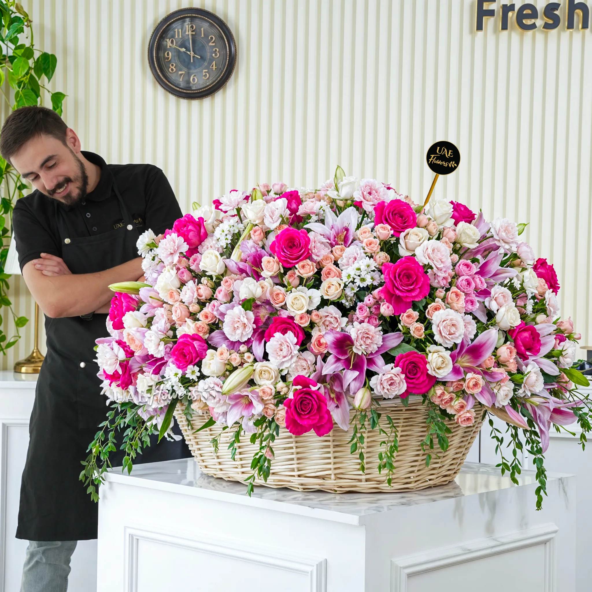 20 Pink Lilies, 50 Peach Spray Roses, 70 Carnations,70 Cream Roses,20 White Mums and 30 Fuchsia Roses arranged in a basket