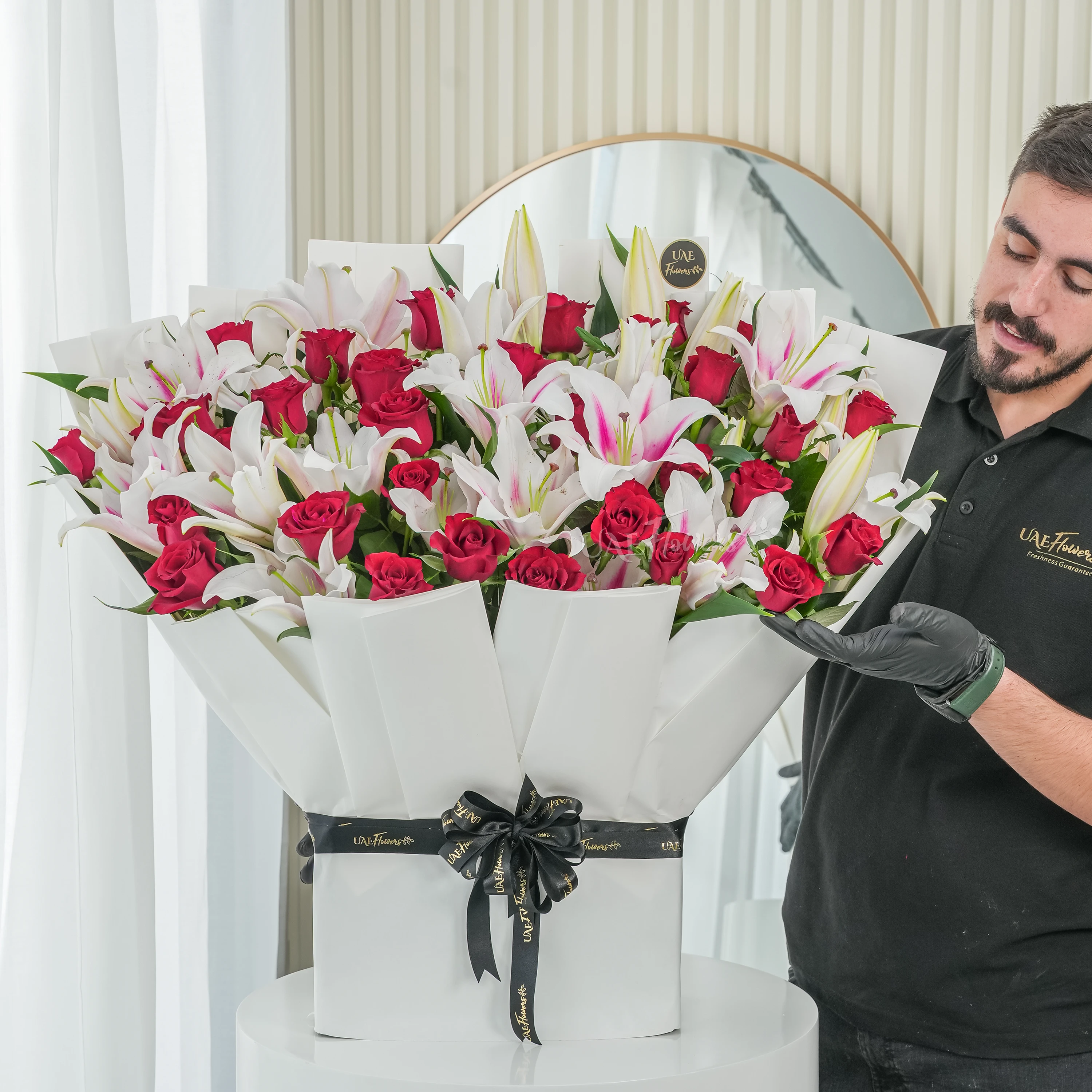 Bouquet of 10 pink lilies and 30 red roses with green fillers tied with ribbons.