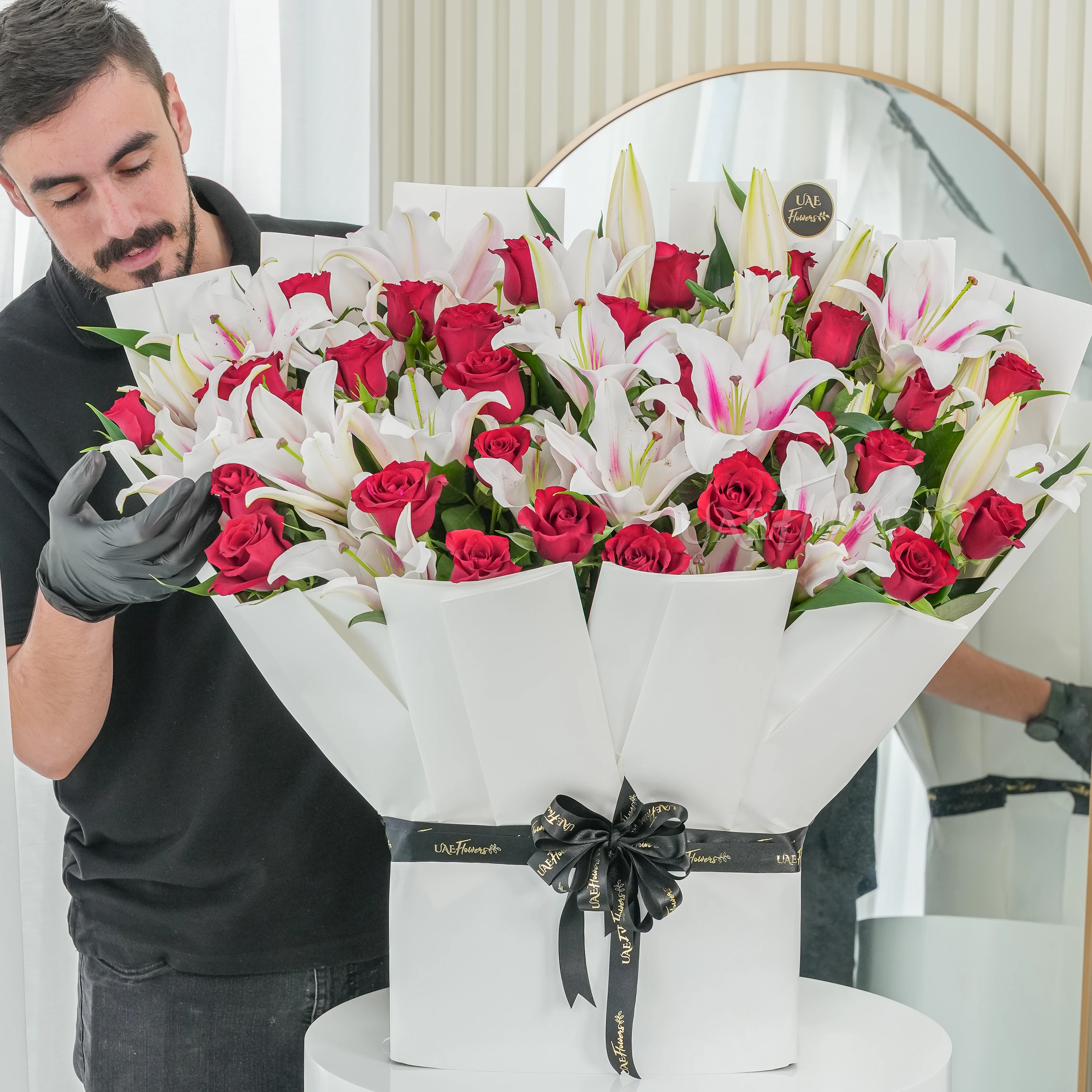 Bouquet of 10 pink lilies and 30 red roses with green fillers tied with ribbons.