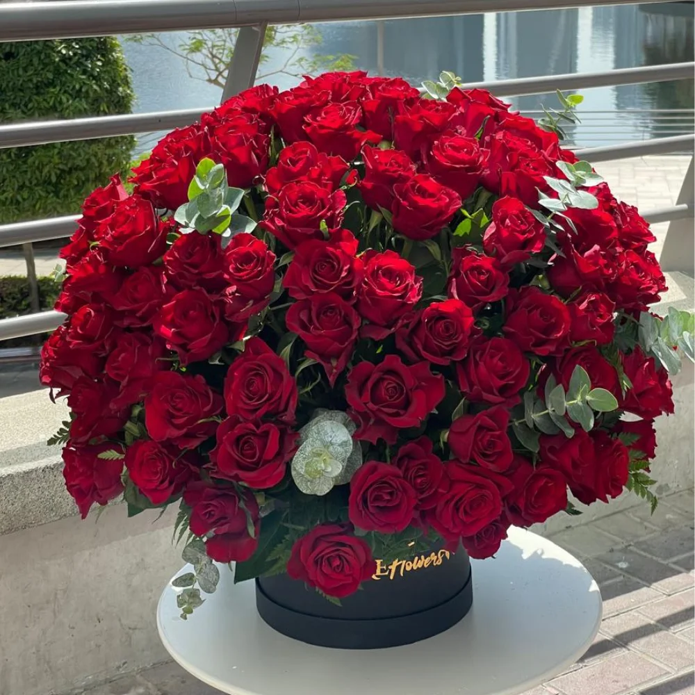 100 red roses box arrangement with eucalyptus in a black box