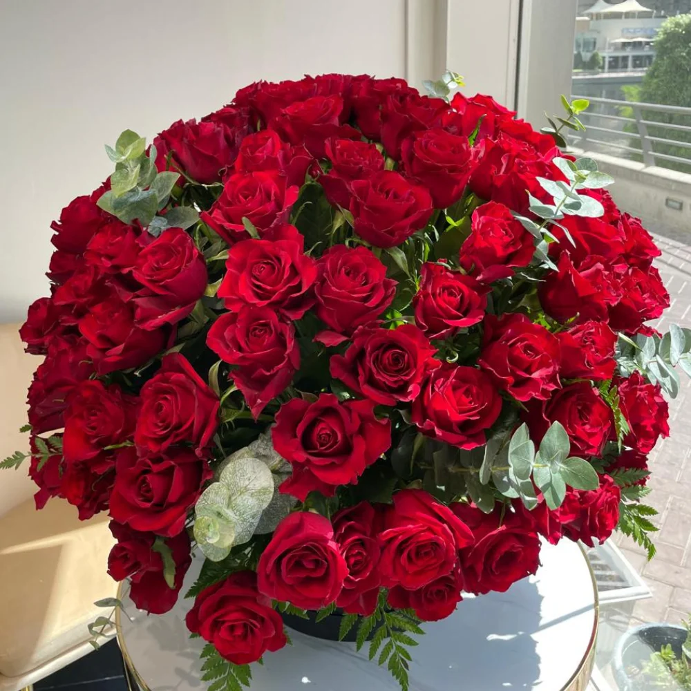 100 red roses box arrangement with eucalyptus in a black box