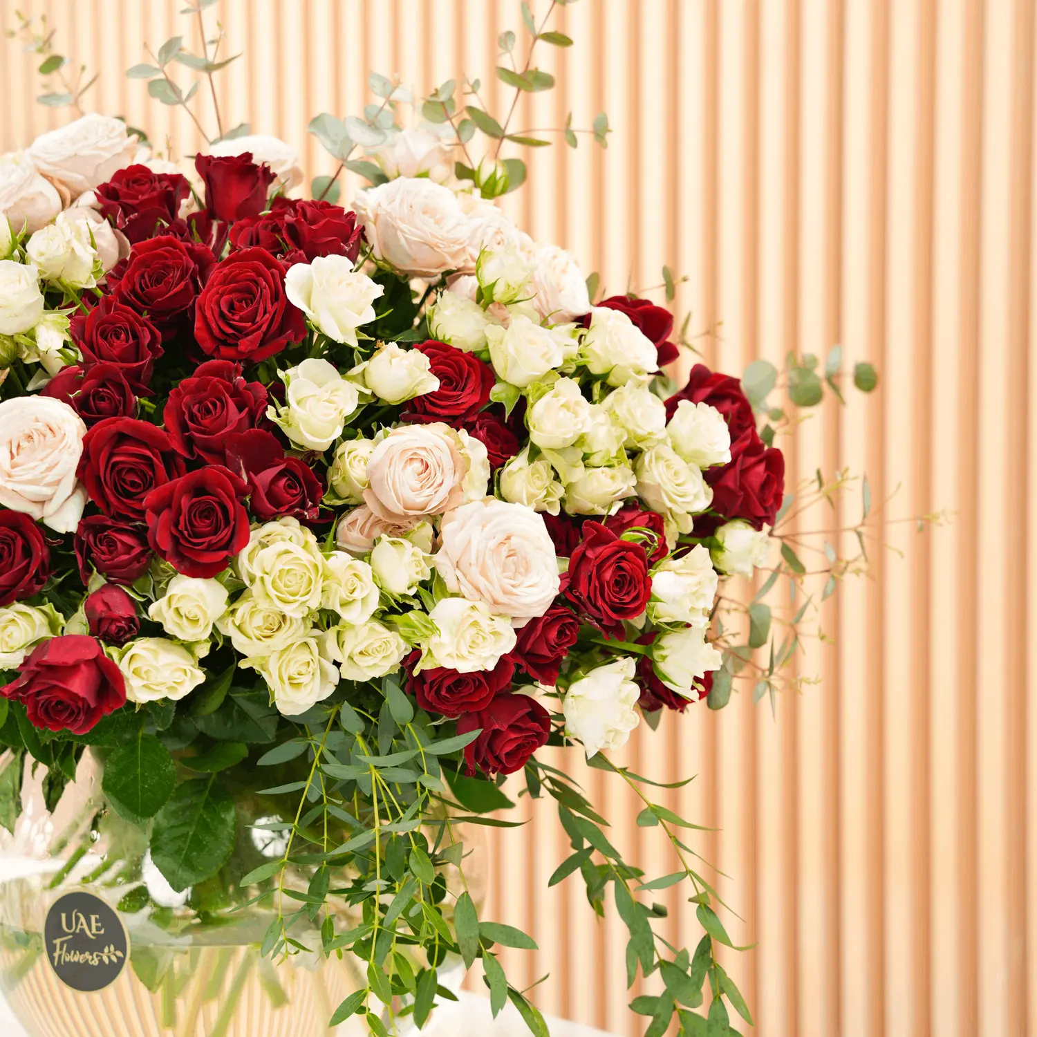 glass vase with red, pink, and white spray roses with green fillers