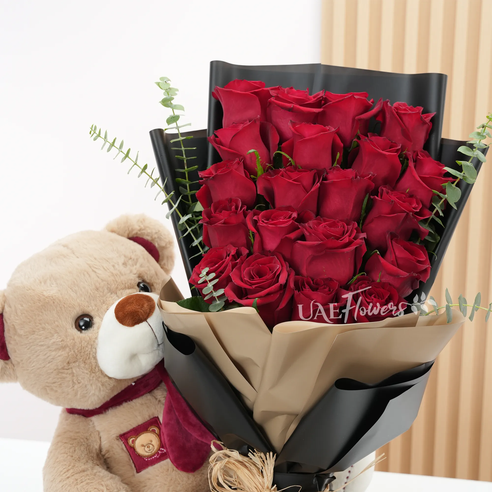 20 red roses with fillers and medium-sized brown teddy.