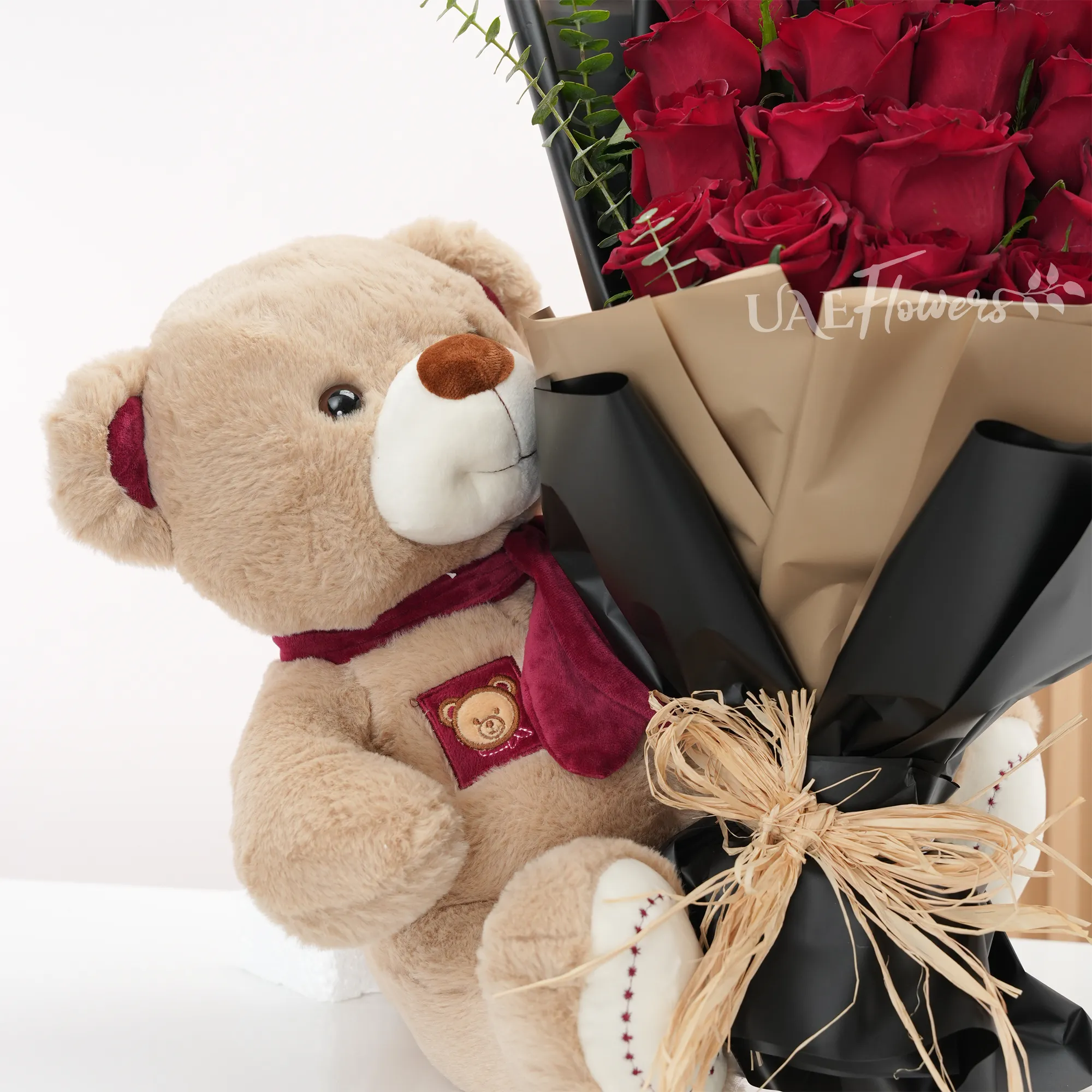 20 red roses with fillers and medium-sized brown teddy.