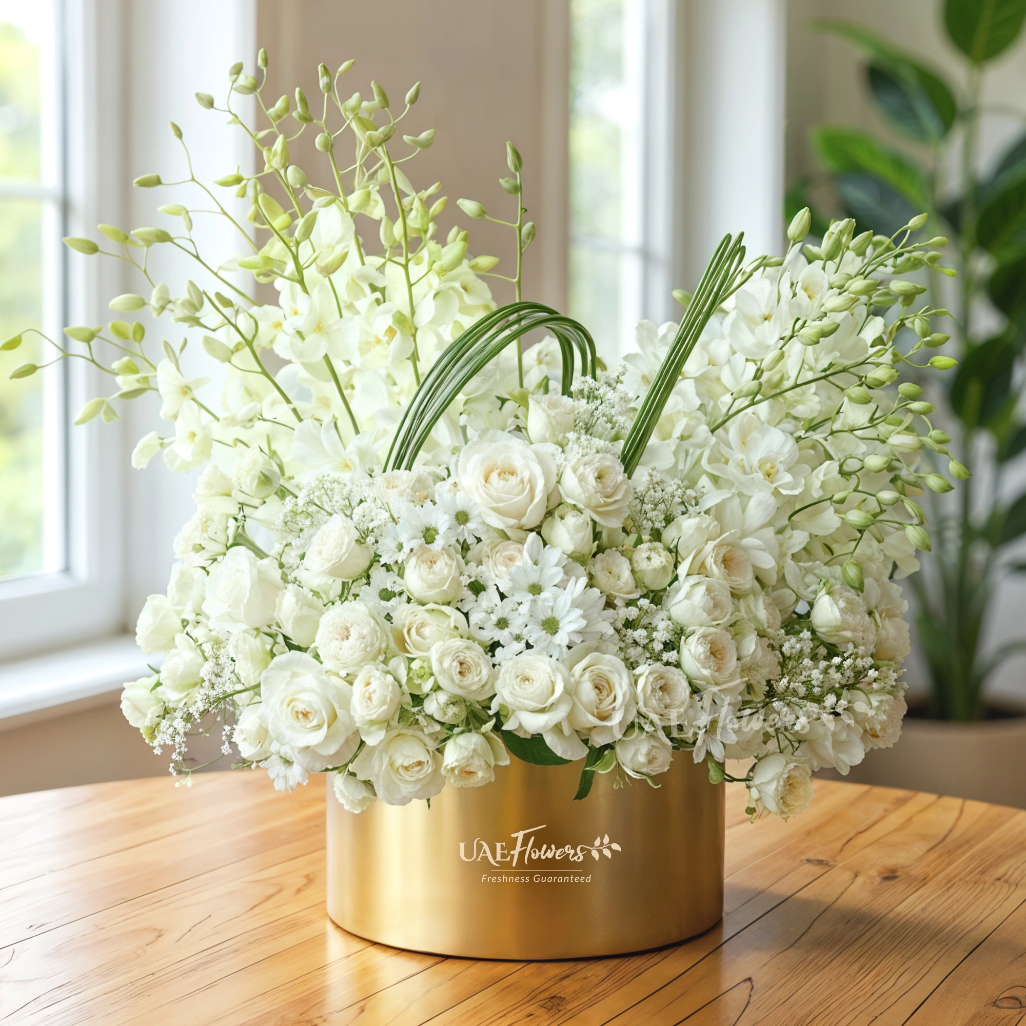 A box arrangement of 20 white orchids, 20 white roses, 5 white spray roses with white chrysanthemums and steel grass.