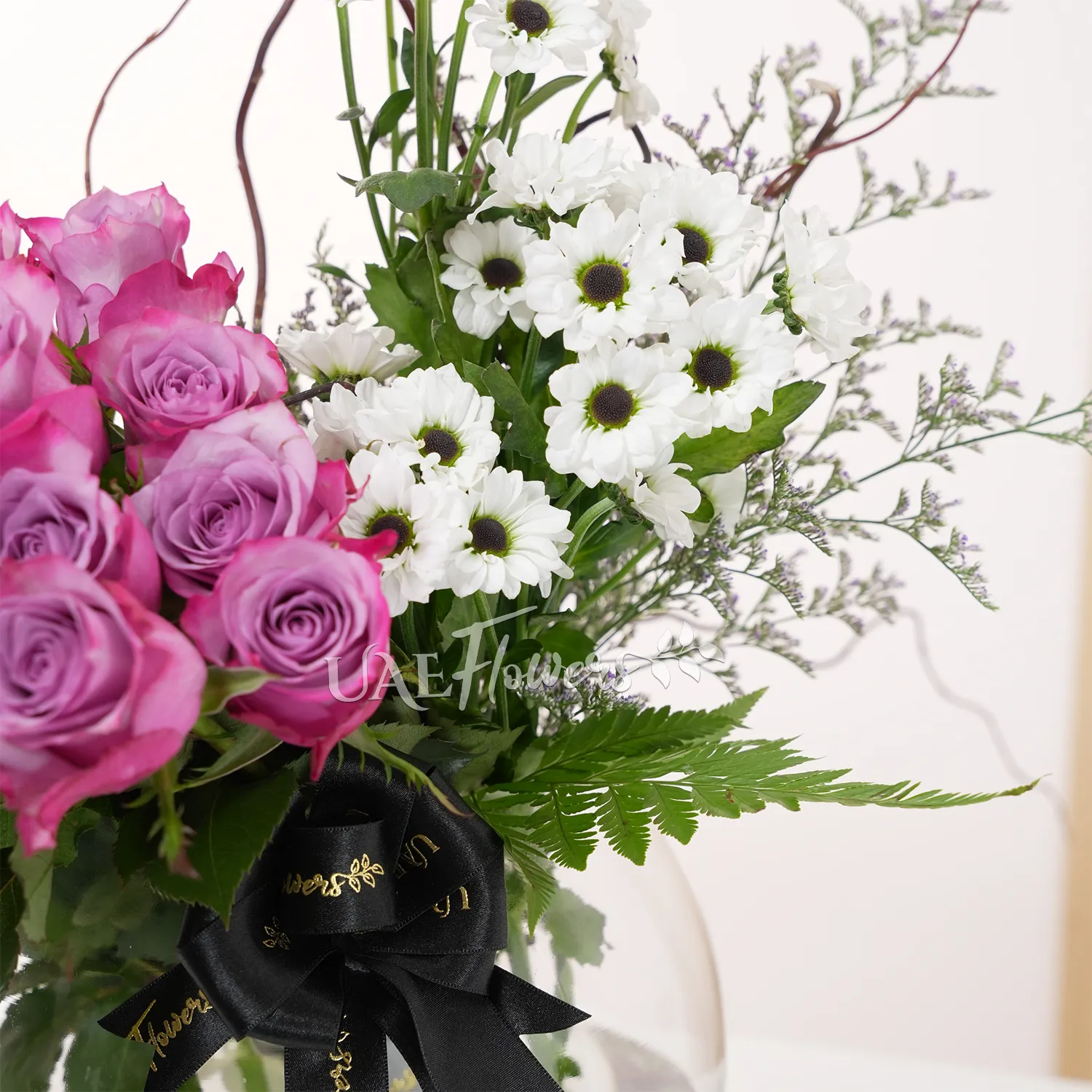 purple roses and white chrysanthemums, accented with lush green fillers