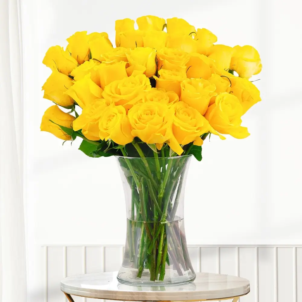 40 yellow roses with greens in a clear glass vase