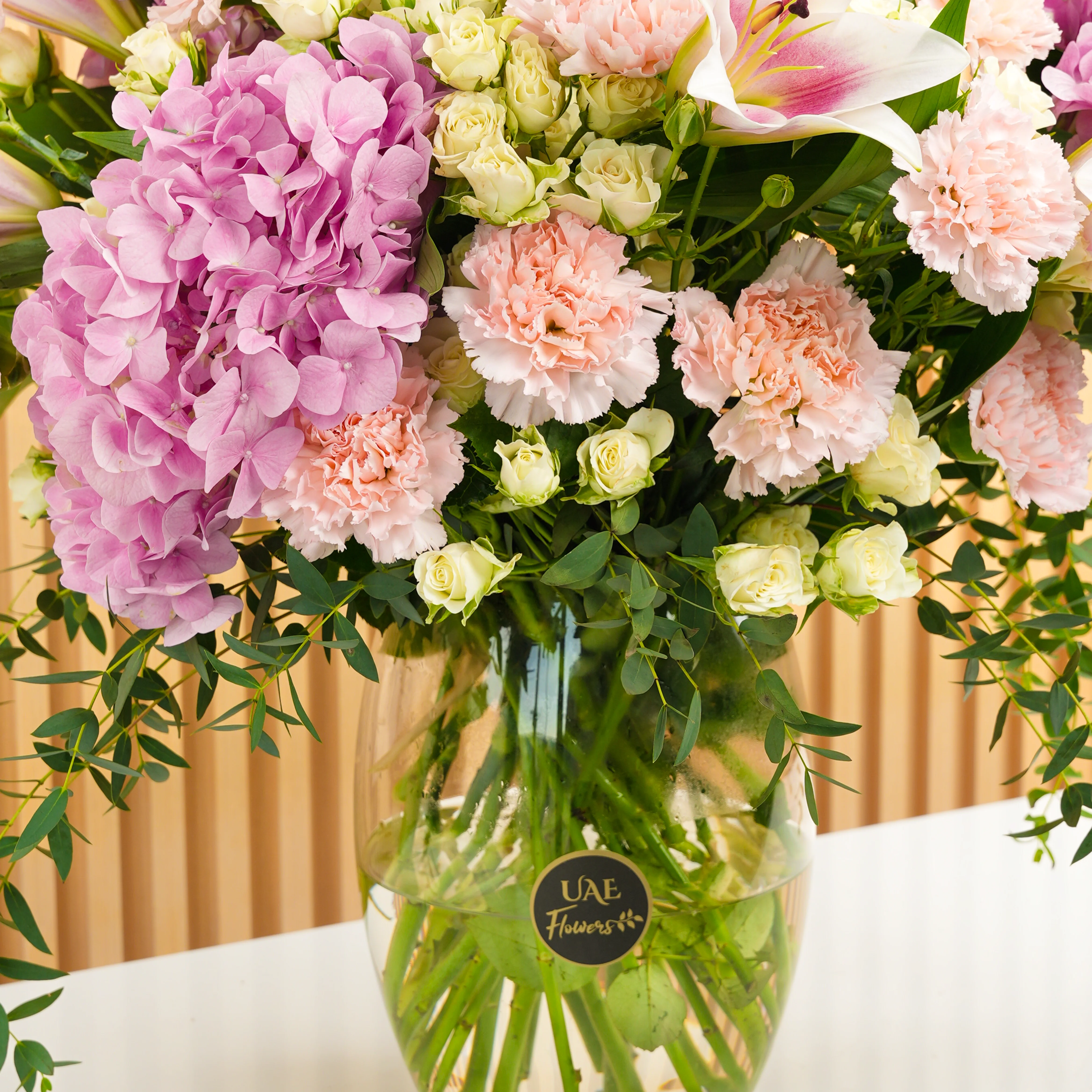 3 pink hydrangeas, 5 pink lilies, 10 pink carnations, and 5 white spray rose