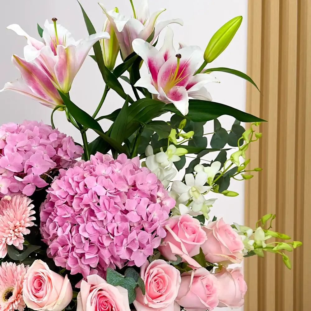 2 pink hydrangeas, 2 pink lilies, 10 pink roses, 3 pink gerberas, and 5 white orchids