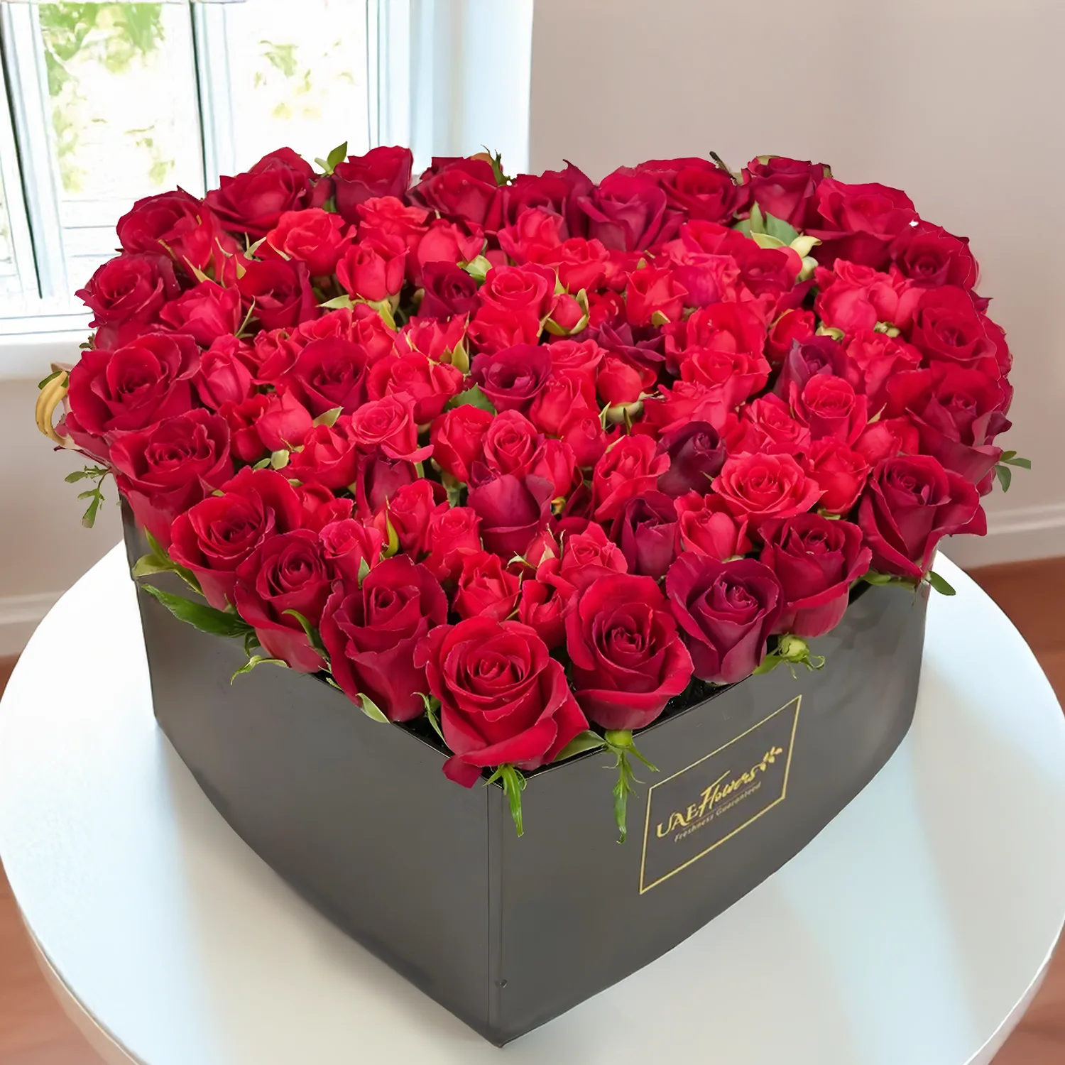 25 red roses and 7 spray roses nicely arranged in a black heart shaped box