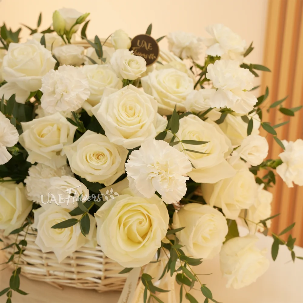 basket arrangement of 15 white carnations and 15 white roses and fillers
